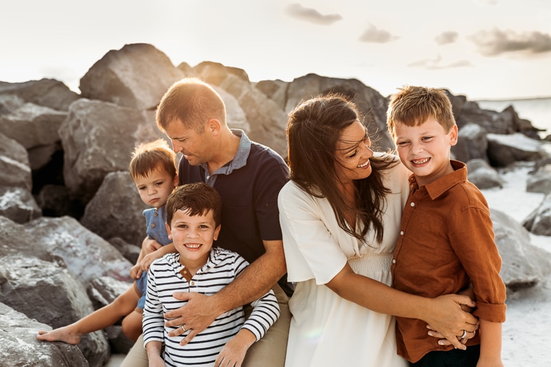 Family Photographer, a family of five embraces each other at the beach